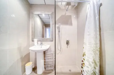 a white bathroom with a sink and a shower at Hospitality Expert Rimal 5BR Marina Beach Pool in Dubai
