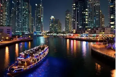 two boats in a river with a city at night at Hospitality Expert Rimal 5BR Marina Beach Pool in Dubai