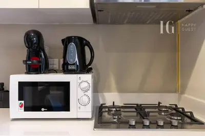 a microwave sitting next to a stove top oven at Modern Comfort in Business Bay in Dubai