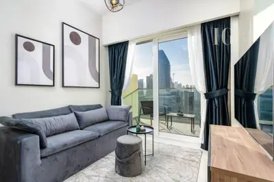 a living room with a couch and a large window at Modern Comfort in Business Bay in Dubai