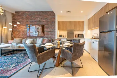 a kitchen and living room with a table and chairs at Designer 1 Bedroom Apartments in Dubai Hills Estate in Dubai