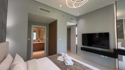 a bedroom with a bed and a flat screen tv at Rosewater at Creek Beach Building 2 Luxury Creekside Living with Beach & Pool Access in Dubai