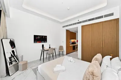 a living room with a white couch and a table at Azizi Riviera Gateway - Highest Floor Superior Apartment in Dubai