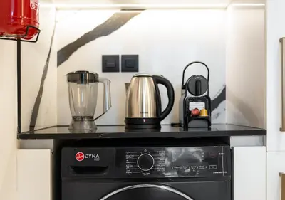 a kitchen with a stove top oven with a blender at Luxury 1 BR Apartment with Private Jacuzzi in Dubai