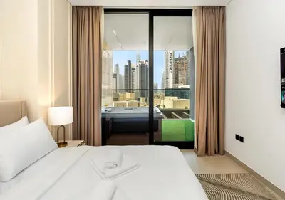 a bedroom with a bed and a view of a city at Luxury 1 BR Apartment with Private Jacuzzi in Dubai