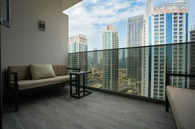 a couch on a balcony with a view of a city at Magnificent living at Downtown in Dubai