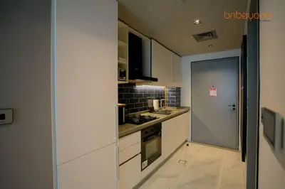 a kitchen with white appliances and a door to a hallway at Magnificent living at Downtown in Dubai