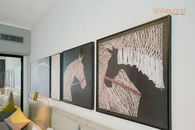 a living room with four paintings on the wall at Magnificent living at Downtown in Dubai