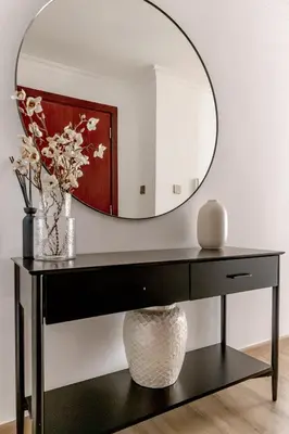 a black console table with a round mirror at Amazing, Spacious 2-bed with fantastic sea view! in Dubai