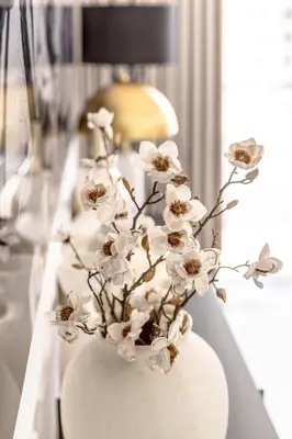 a white vase with white flowers on a table at Amazing, Spacious 2-bed with fantastic sea view! in Dubai