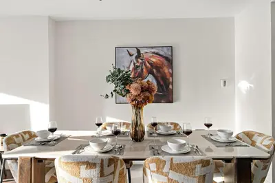 a dining room table with a vase with a horse painting at FIRST CLASS 2BR Spacious DIFC Living in Dubai