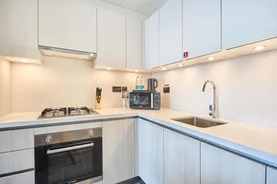 a kitchen with white cabinets and a sink at STAY BY LATINEM Luxury 1BR Plus Study Holiday Home CB 3714 Near Burj Khalifa in Dubai