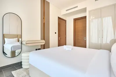 a bedroom with a large white bed and a mirror at STAY BY LATINEM Luxury 1BR Plus Study Holiday Home CB 3714 Near Burj Khalifa in Dubai