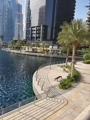 a walkway next to a body of water with buildings at Stunning lake view 1bedroom apartment in Jlt in Dubai