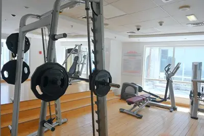 a gym with several tread machines in a room at Stunning lake view 1bedroom apartment in Jlt in Dubai