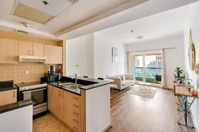 a kitchen with a sink and a living room at Stunning lake view 1bedroom apartment in Jlt in Dubai