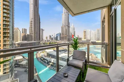 a balcony with a chair and a view of the city at Durrani Homes - Minimal Luxe 3BR with Burj Khalifa and fountain view - third room without partition in Dubai