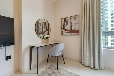 a room with a table and a mirror and a chair at Durrani Homes - Minimal Luxe 3BR with Burj Khalifa and fountain view - third room without partition in Dubai