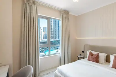 a bedroom with a bed and a large window at Durrani Homes - Minimal Luxe 3BR with Burj Khalifa and fountain view - third room without partition in Dubai