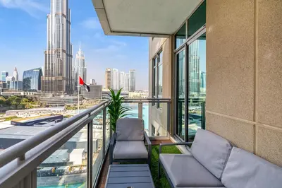 a balcony with two chairs and a view of the city at Durrani Homes - Minimal Luxe 3BR with Burj Khalifa and fountain view - third room without partition in Dubai