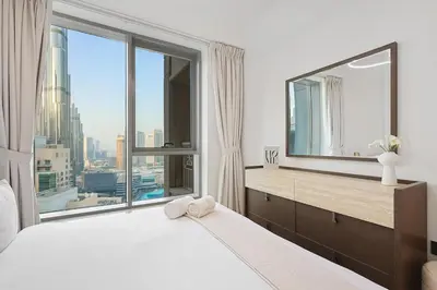 a bedroom with a large window with a view of the city at FIRST CLASS 2BR Burj Views & Classy Comfort in Dubai