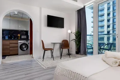 a bedroom with a bed and a table with chairs at Waves - Cozy & Fully Furnished Studio in Dubai Sports City in Dubai