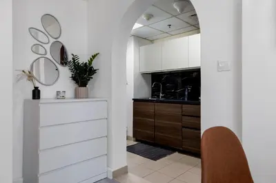 a kitchen with white cabinets and a sink at Waves - Cozy & Fully Furnished Studio in Dubai Sports City in Dubai