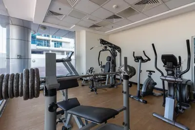 a gym with treadmills and cardio equipment in a building at Waves - Cozy & Fully Furnished Studio in Dubai Sports City in Dubai