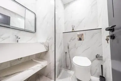 a white bathroom with a toilet and a sink at Luxury 2BR - Stunning Marina View and JBR Beach in Dubai