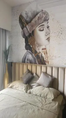 a painting of a woman on a wall above a bed at Charming Designed Apt - RIVIERA 26 Residence - Close to downtown in Dubai