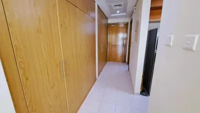 a hallway with wooden cabinets and a hallway with a door at DRUVYA HOLIDAY HOMES, Building No 194, Street No,10 Discovery Gardens, Close to Al Furjan Metro 3 minutes walkable in Dubai
