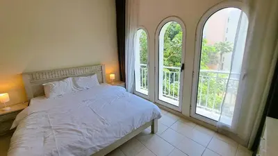 a bedroom with a bed and two large windows at DRUVYA HOLIDAY HOMES, Building No 194, Street No,10 Discovery Gardens, Close to Al Furjan Metro 3 minutes walkable in Dubai