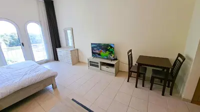 a bedroom with a bed and a table with a television at DRUVYA HOLIDAY HOMES, Building No 194, Street No,10 Discovery Gardens, Close to Al Furjan Metro 3 minutes walkable in Dubai