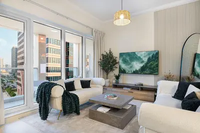 a living room with white furniture and large windows at The Haven Burj Khalifa View - 1BR Business Bay with Balcony&Pool in Dubai