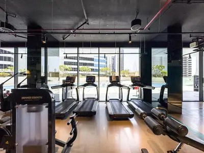 a gym with a row of treadmills at Deluxe Studio Business Bay - Balcony City Skyline Views in Dubai
