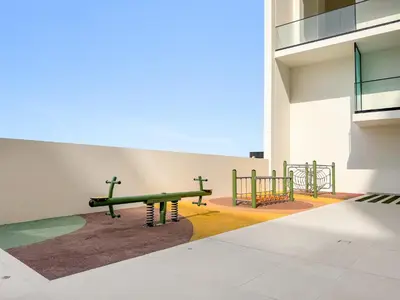 a playground with a green bench in a building at Modern Studio with Pool & Gym - Prime JVC Location in Dubai
