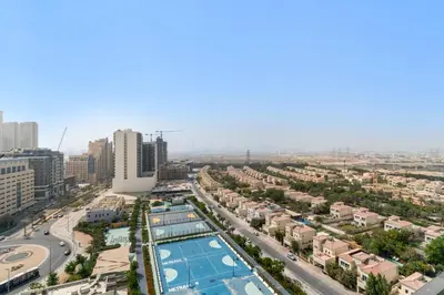 an aerial view of a city with a pool at Modern Studio with Pool & Gym - Prime JVC Location in Dubai