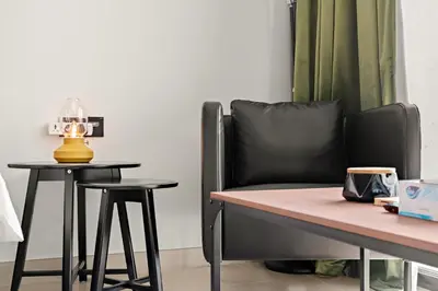 a chair next to a table with a lamp on it at Modern Studio with Pool & Gym - Prime JVC Location in Dubai