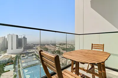 a table and chairs on the balcony of a building at Modern Studio with Pool & Gym - Prime JVC Location in Dubai