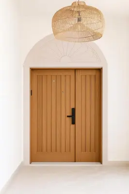 a wooden door in a room with a chandelier at Family Villa, Sleeps up to 9 in JVT and Large garden in Dubai