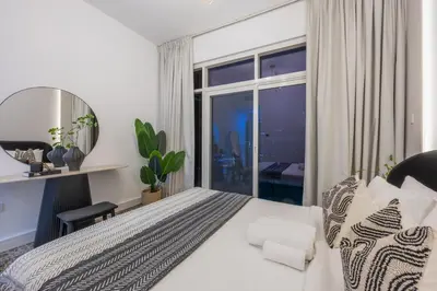 a bedroom with a large bed and a large window at Exceptional 2BR with Marina Waterfront View in Dubai