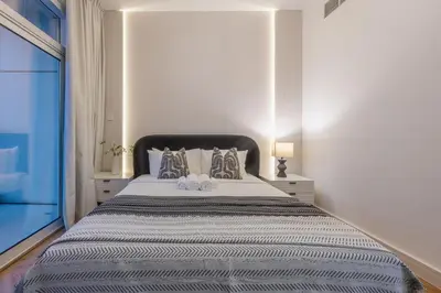 a white bedroom with a large bed with two pillows at Exceptional 2BR with Marina Waterfront View in Dubai