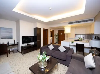 a living room with a couch and a tv at Emaar Residenc Fashion Avenue - Sokoon in Dubai