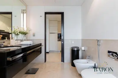 a bathroom with a sink and a tub and a toilet at The Majestic in Dubai