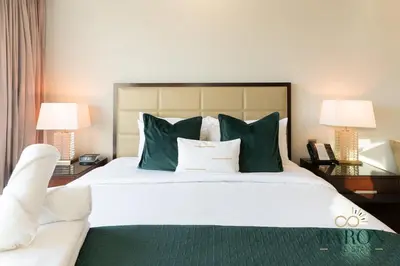 a bedroom with a large bed with green and white pillows at The Glamorous in Dubai