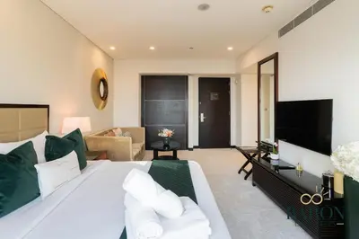 a bedroom with a large bed and a living room at The Glamorous in Dubai
