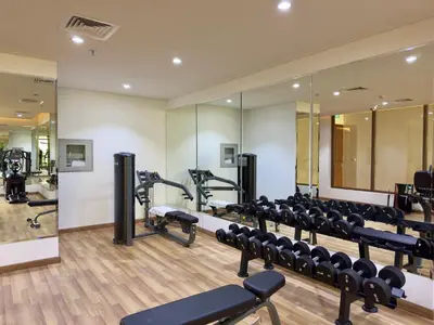 a gym with treadmills and machines in a room at Brand New Stylish Unit near Circle Mall in Dubai