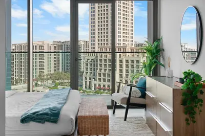 a bedroom with a bed and a large window at Palace Residence Chic 2BR Creek Beach View in Dubai