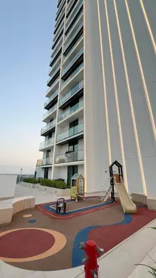 a large building with a playground in front of it at Luxury Top Floor Apartment in JVC in Dubai