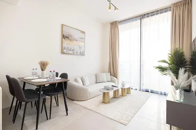 a white living room with a table and a couch at Luxury Top Floor Apartment in JVC in Dubai